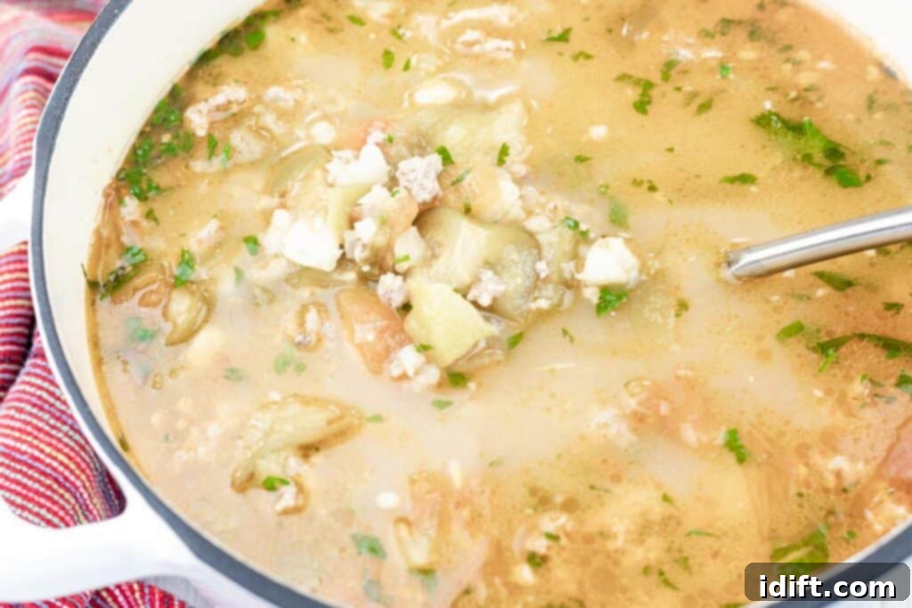 A large pot of vibrant Green Pork Posole soup, brimming with ground meat, chopped tomatillos, hominy, and herbs in a rich, green broth. A metal ladle rests in the pot, inviting diners to serve themselves from the hearty stew.