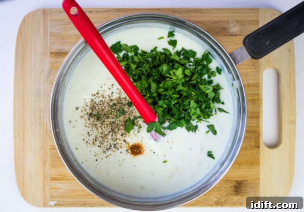 parsley and spices added to the cheesy cream sauce