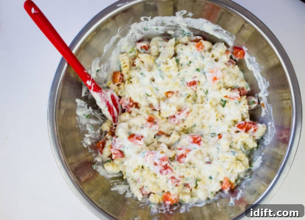 cheese sauce added to the pasta with tomatoes folded in