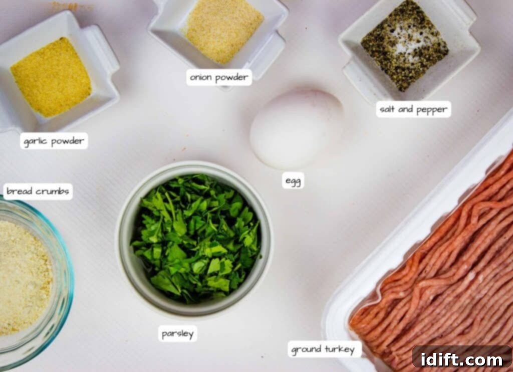 All ingredients for Air Fryer Turkey Meatballs laid out: ground turkey, an egg, fresh parsley, breadcrumbs, garlic powder, onion powder, salt, and pepper.