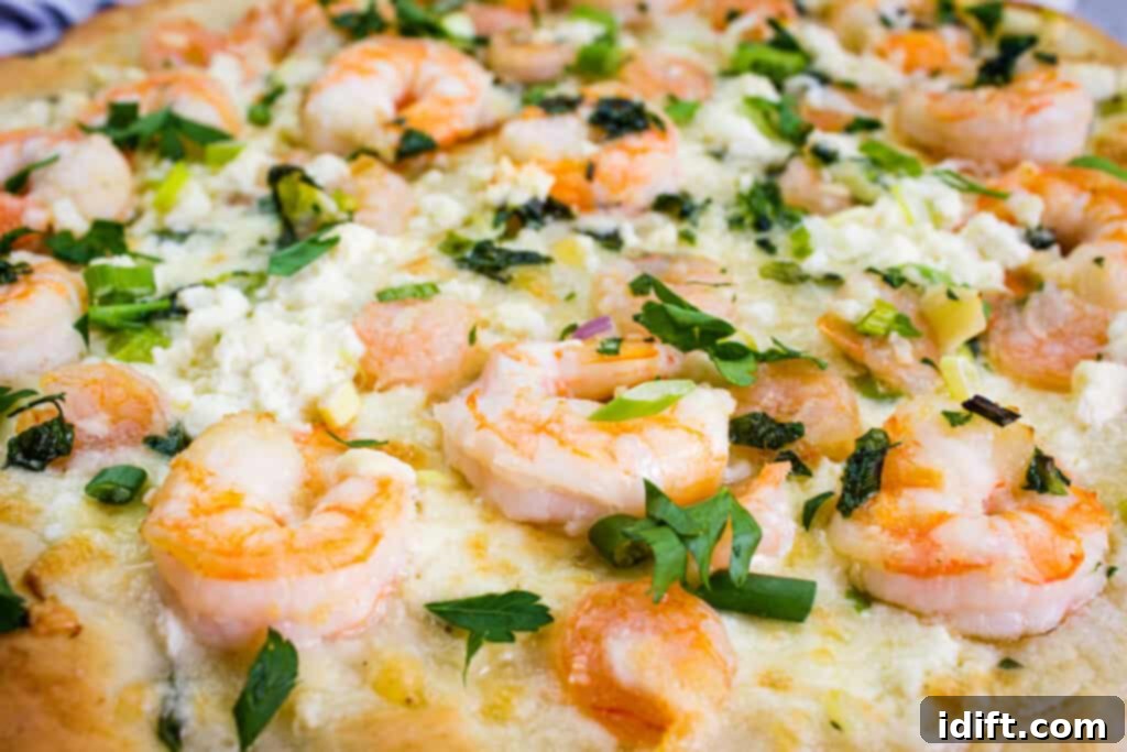 Lemon-Garlic Shrimp Pizza 10 A close-up of a freshly baked shrimp scampi pizza, showing the tender shrimp, melted cheese, and herbs.