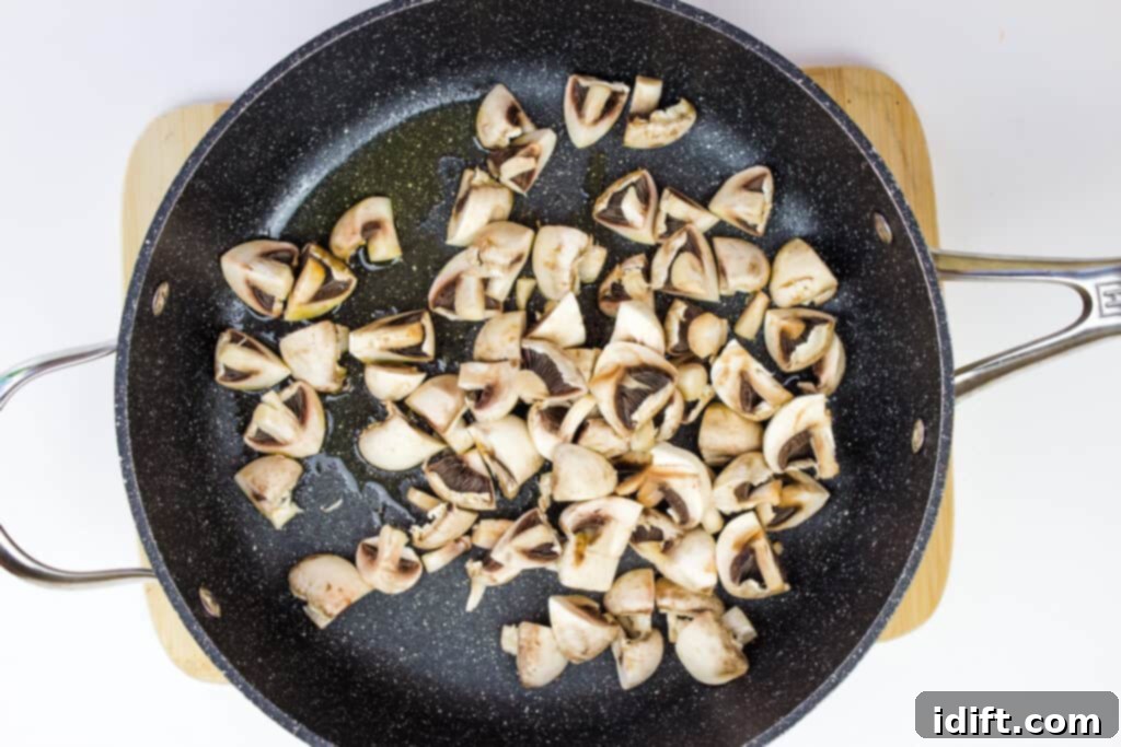 Savory Marsala Chicken Meatballs 10 Mushrooms being sautéed in a skillet with melted butter until golden brown.