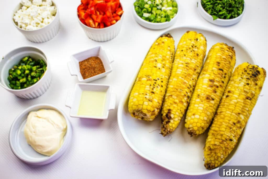 Prepped ingredients to make easy street corn salad recipe, including grilled corn on the cob and diced vegetables.