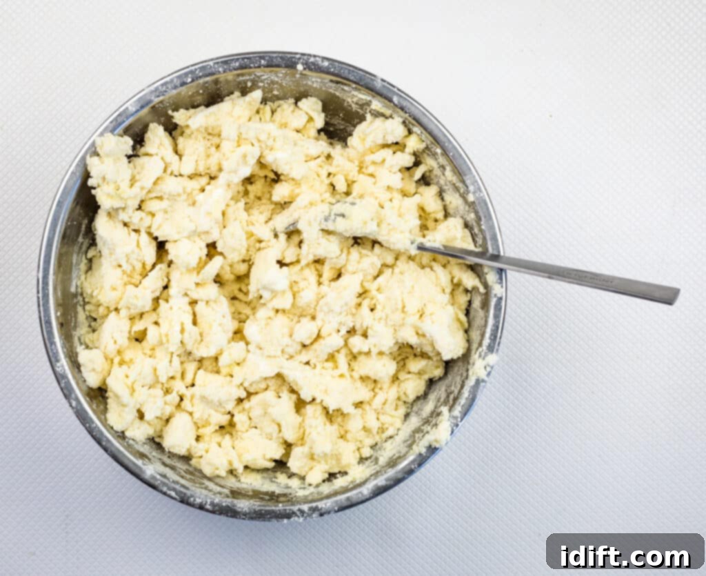 The biscuit dough, mixed to a shaggy consistency, ready to be dropped onto the blueberries.