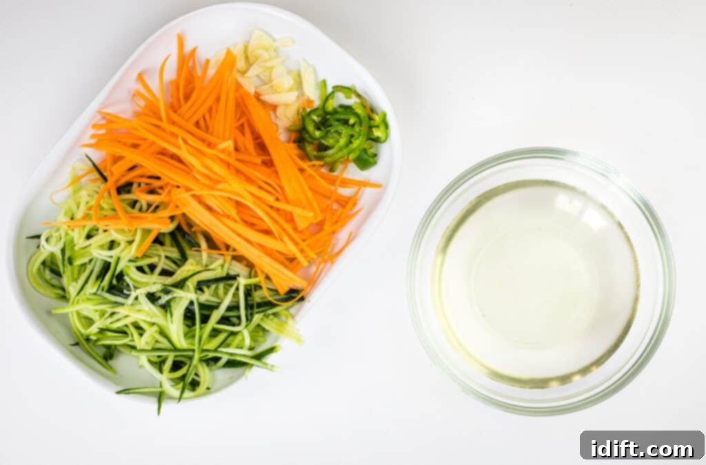 julienned vegetables on a plate next to the mixed pickling liquid