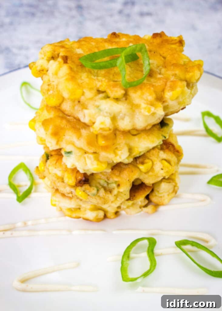 Simple Jalapeno and Applewood Smoked Cheddar Corn Fritters 2 corn fritters with jalapeno and applewood smoked cheddar in a stack
