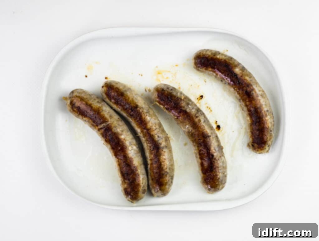 Perfect Sous Vide Sausages 9 sous vide sausage being browned in a hot skillet with oil