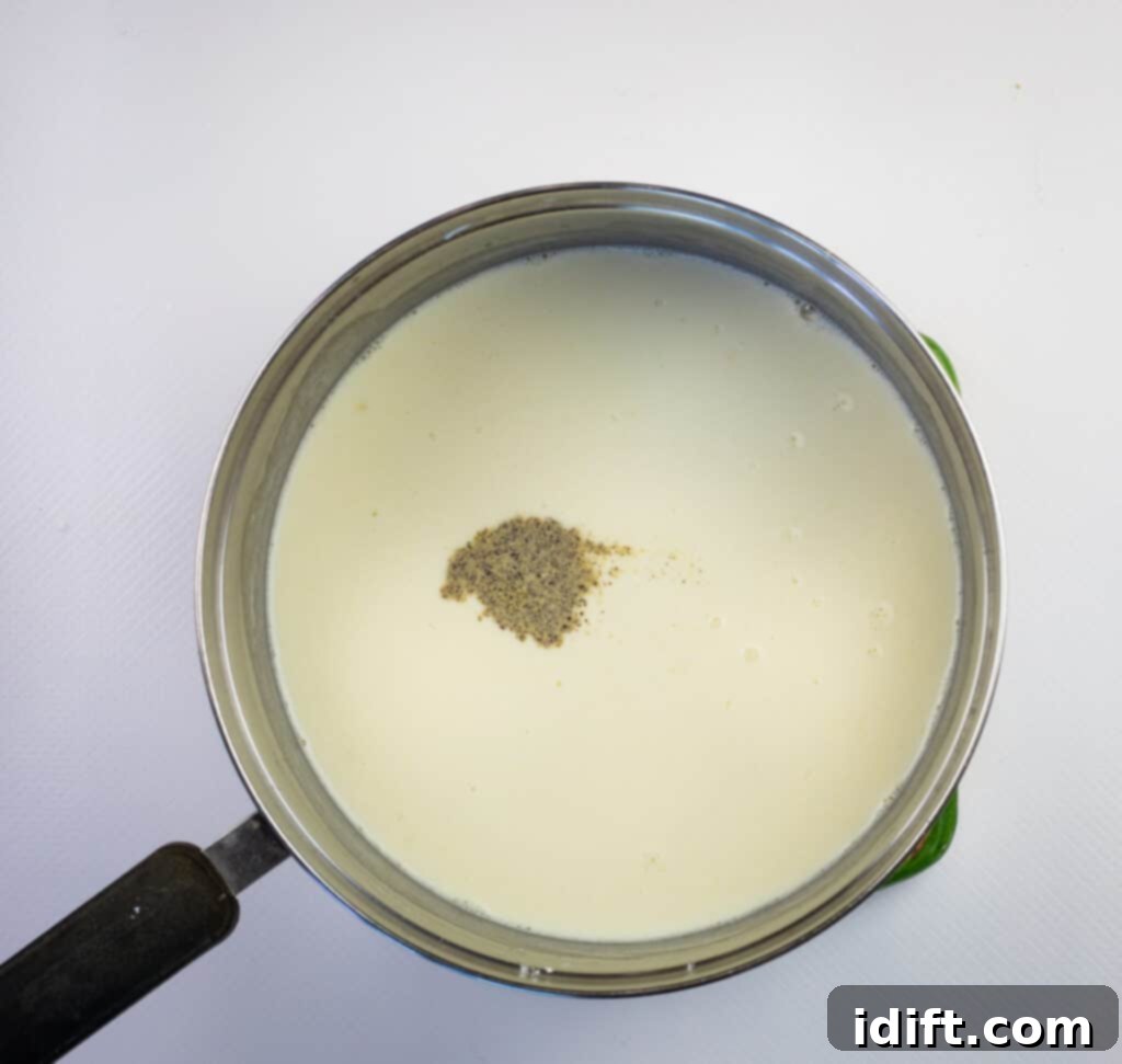 adding cream and milk to the roux