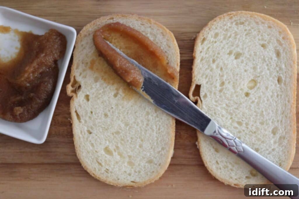 Spread a thin layer of sweet apple butter on the unbuttered side of the bread.