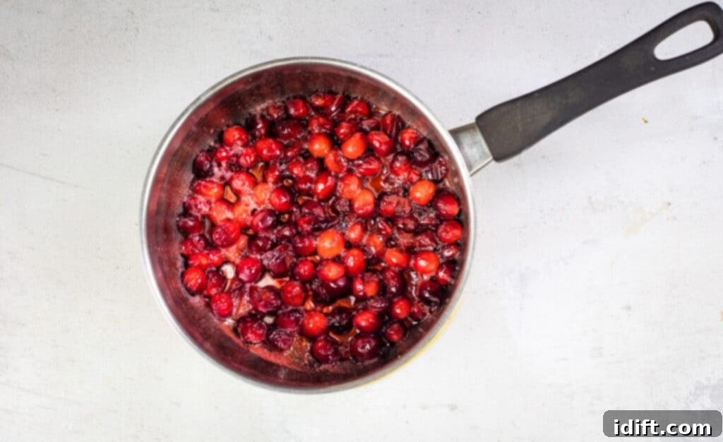 Tangy Cranberry Squares 12 A close-up of the cooked cranberry mixture, showing berries that have popped but still retain some texture, forming a syrupy base.