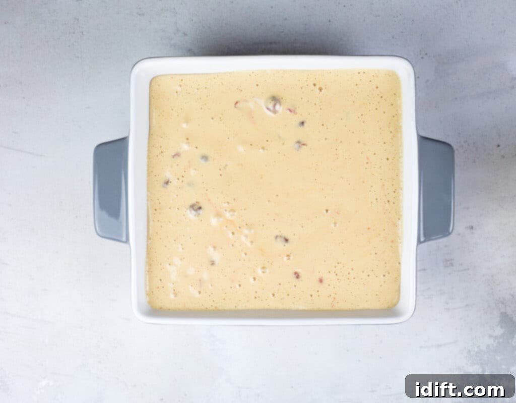 Tangy Cranberry Squares 16 The mixed cranberry and egg batter being poured smoothly over the pre-baked shortbread crust in the pan.