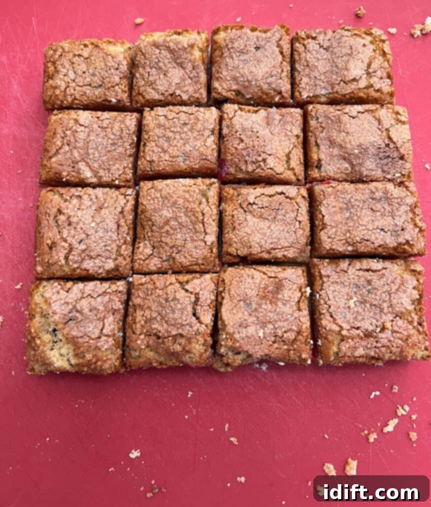 Tangy Cranberry Squares 5 Cranberry bars transferred to a cutting board, neatly sliced into uniform squares.