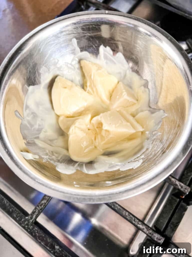 Tangy Cranberry Squares 6 White chocolate being gently melted in a double boiler, ensuring a smooth, lump-free consistency for the drizzle.