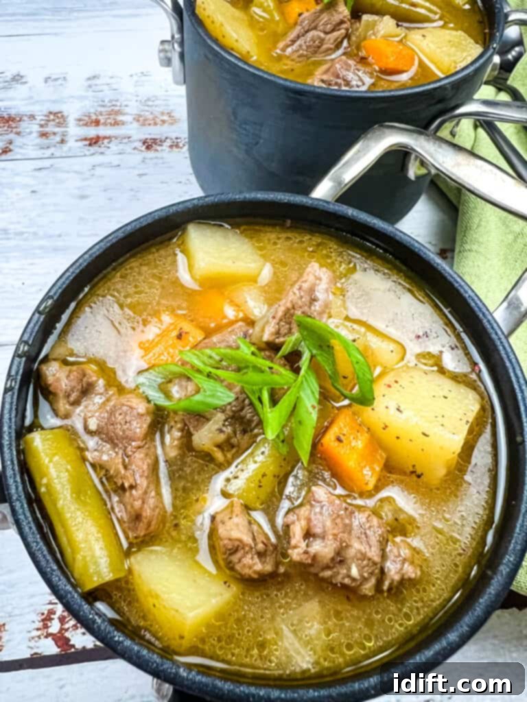 Steak & potato soup in a small black bowl