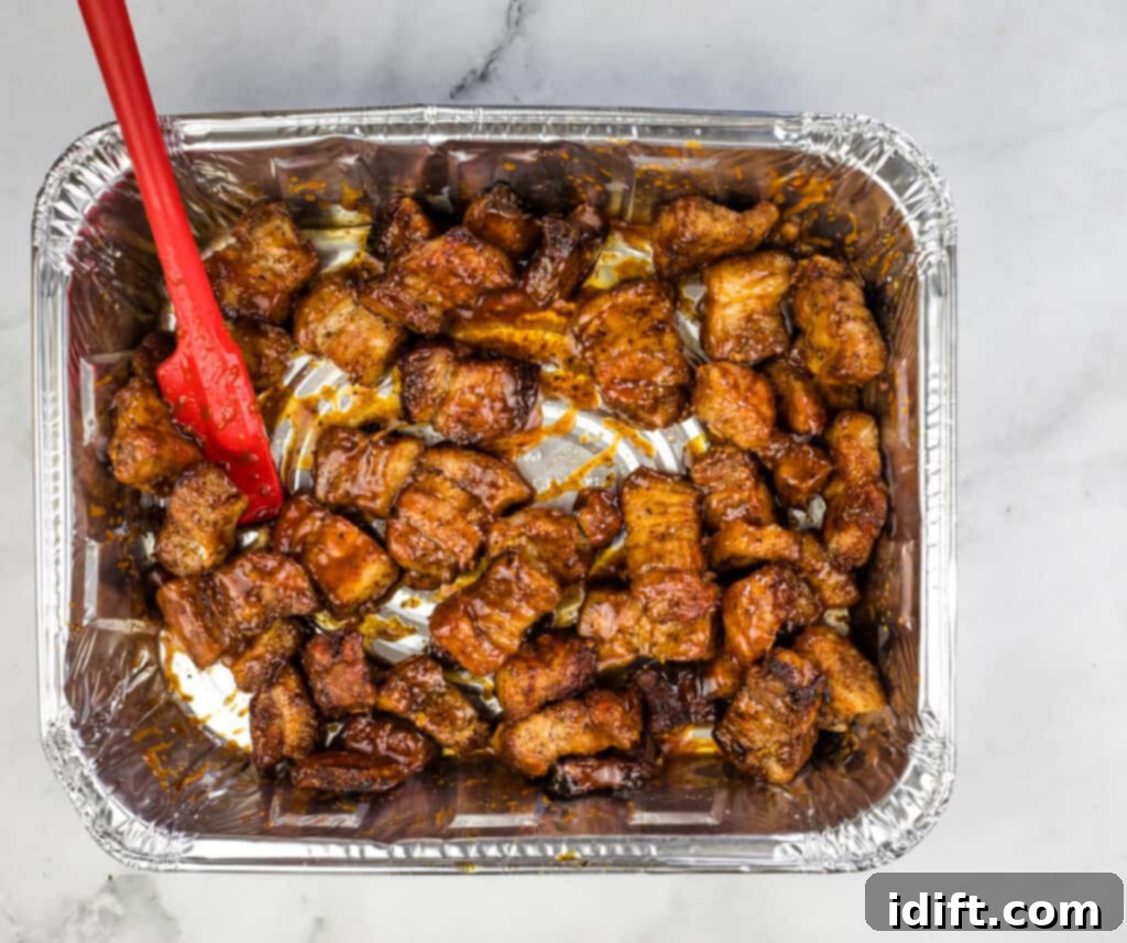 adding sauce and honey to pork belly burnt ends