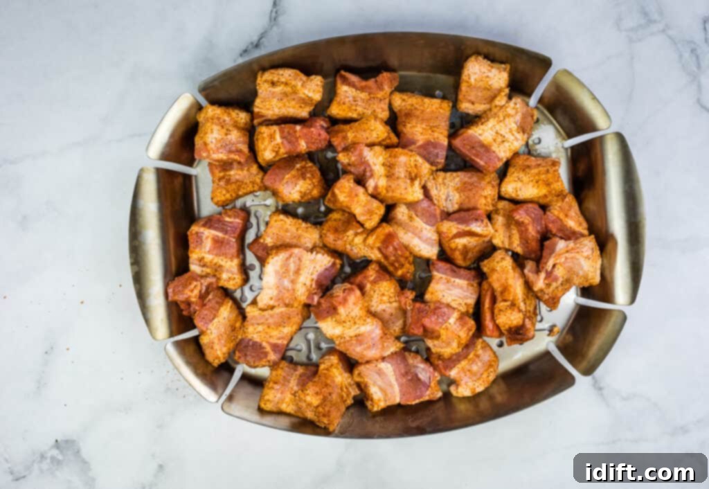 pork belly cubes on a grill pan in the smoker