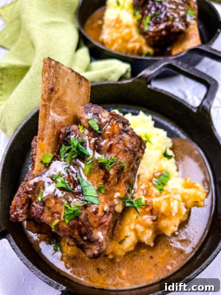 Deeply browned garlic braised short ribs in a sleek black serving dish, ready to be enjoyed.
