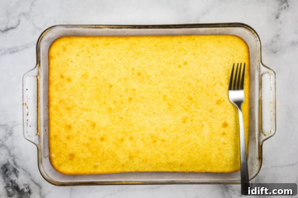 A freshly baked Eggnog Tres Leches cake, golden brown and ready to be poked.