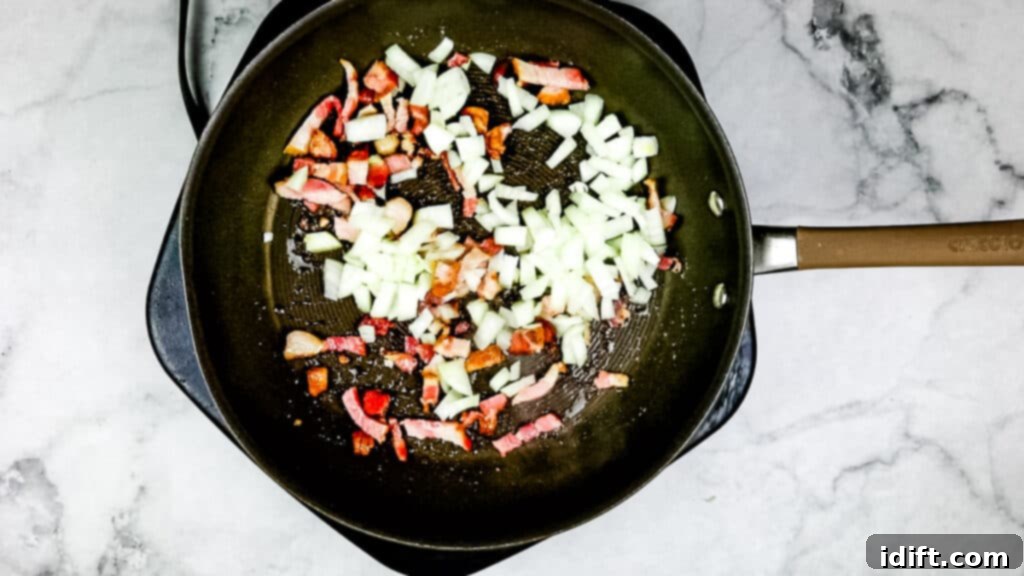 Adding diced onion to the skillet with cooked bacon and rendered fat.