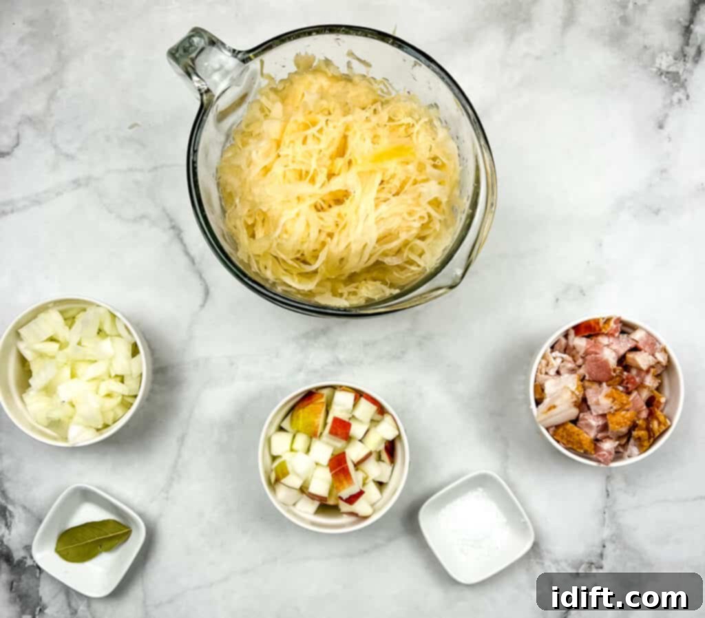 Ingredients for making sauerkraut with bacon and apple, including a jar of sauerkraut, bacon slices, an apple, an onion, and seasoning.