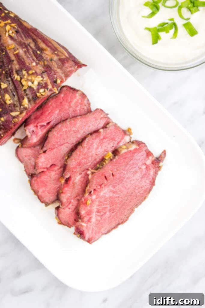 Four slices cut from a Smoked Beef Tenderloin on a white plate.