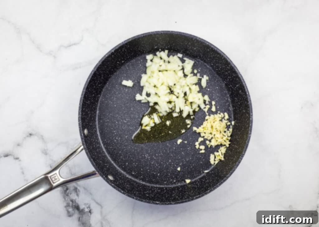 Hearty Vegan Mexican Grain Bowl 4 sauteeing onion and garlic in a skillet to make vegan spanish rice