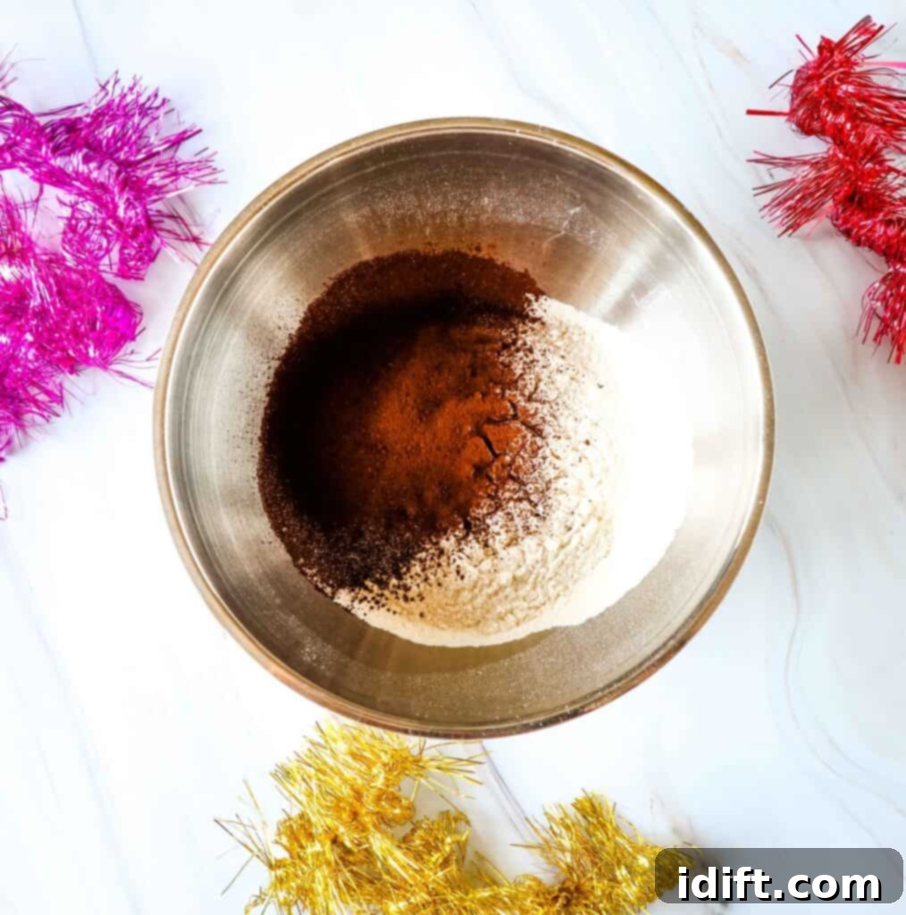 Mixing dry ingredients (flour, cocoa, spices) in a large bowl with a whisk.