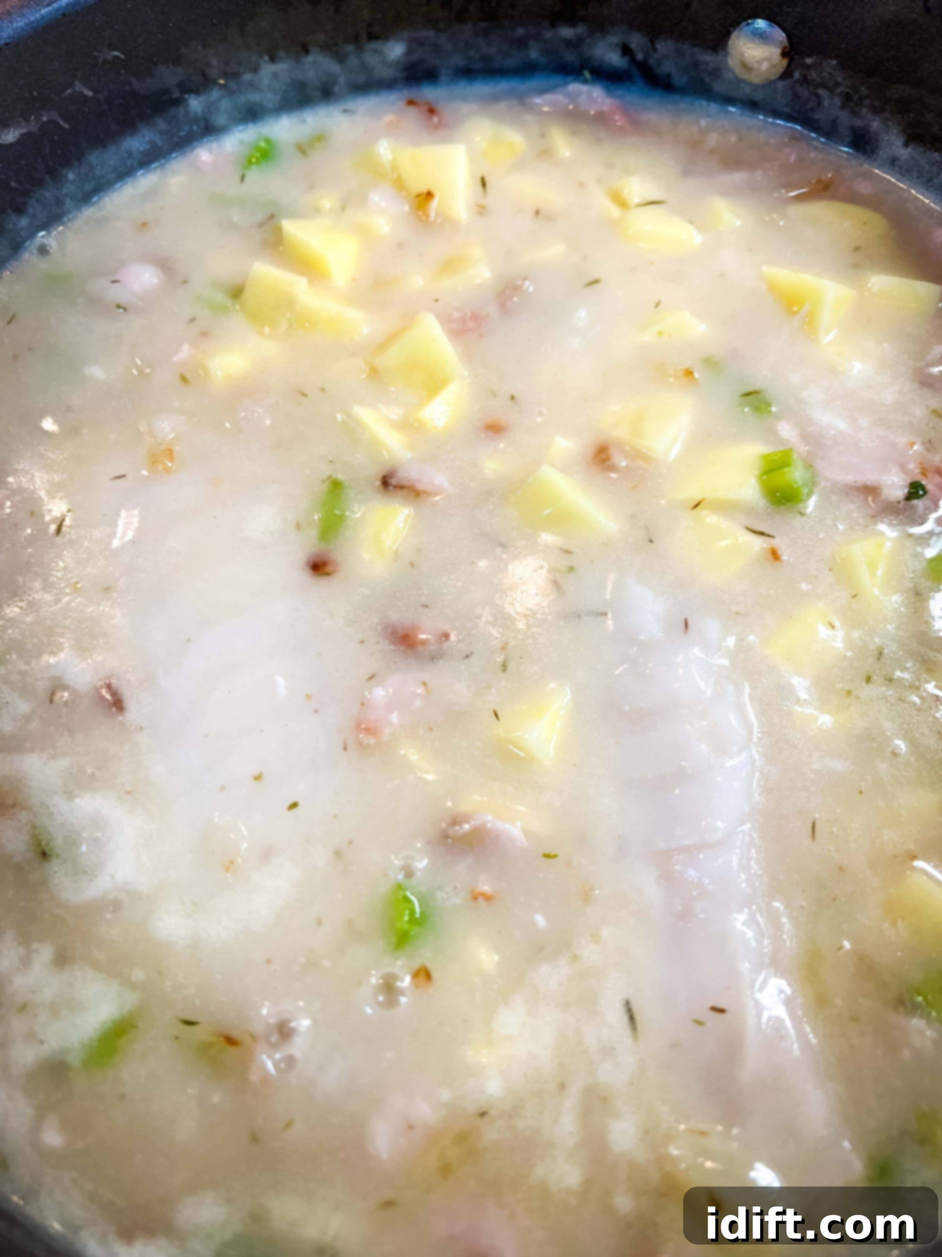 Add the clam juice and seafood broth. Simmer.