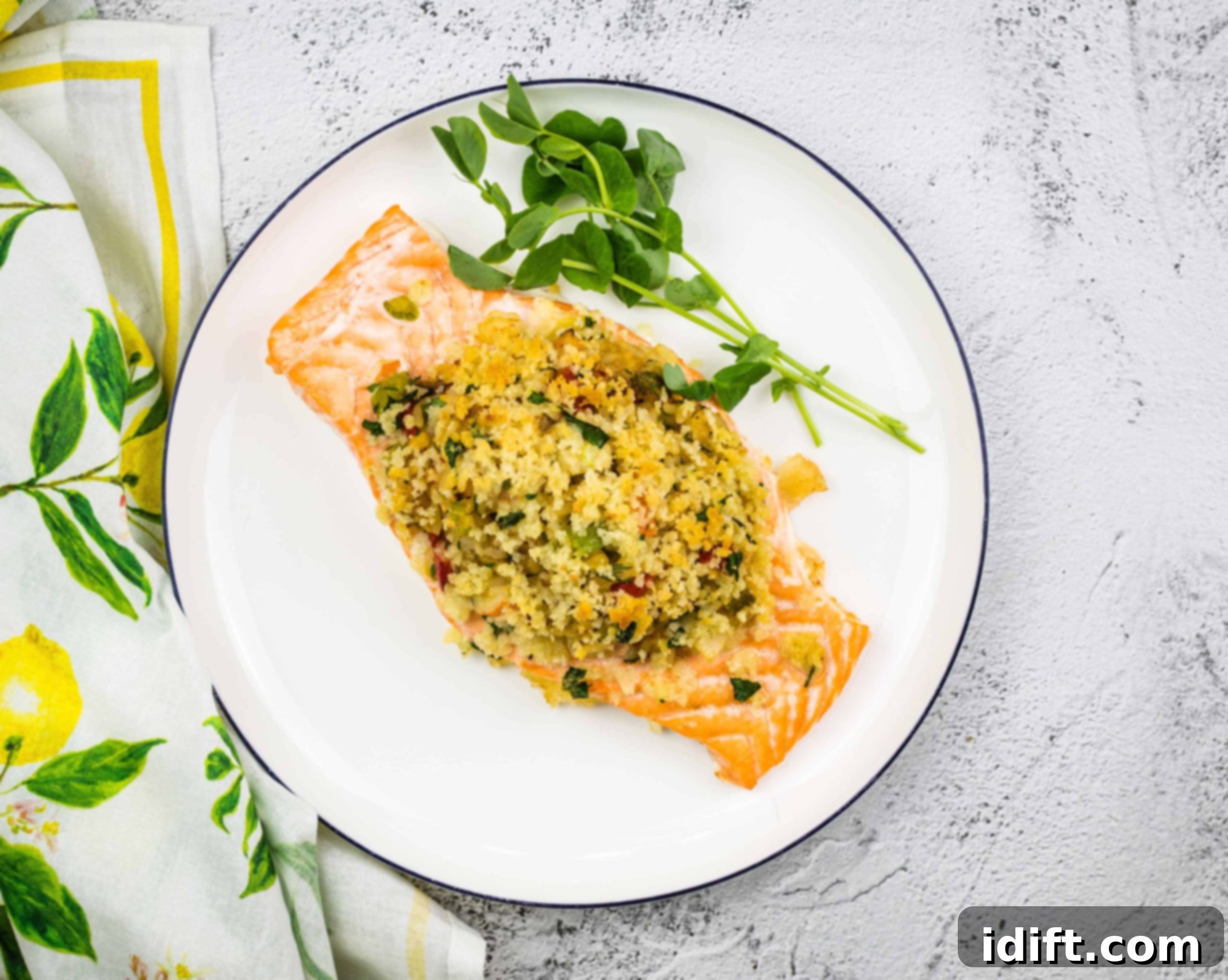 Cooked seafood stuffed salmon on a plate, garnished with fresh lemon.