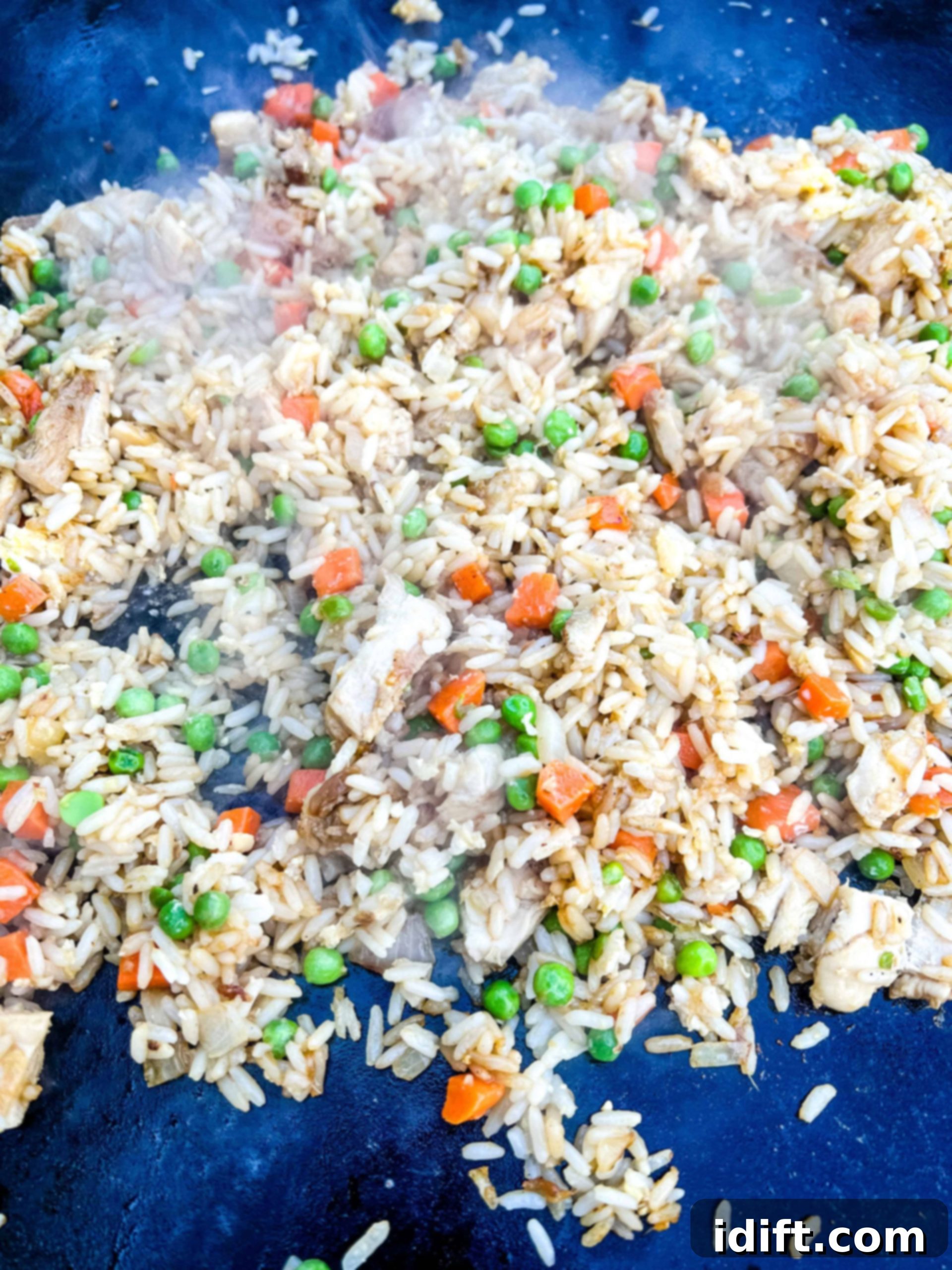 Mixing peas and various seasonings, including soy sauce and fish sauce, into the fried rice.
