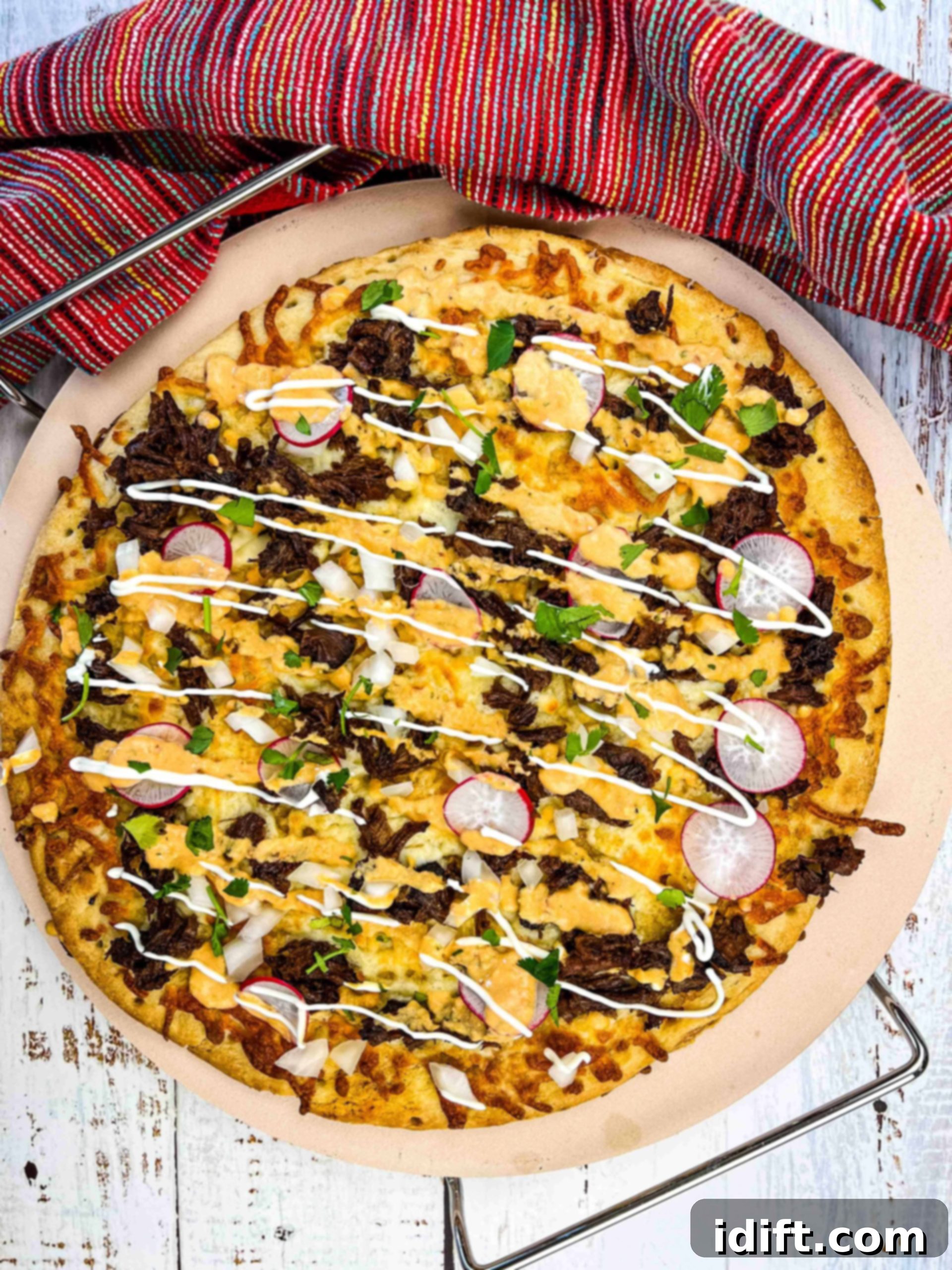 birria pizza on a pizza stone