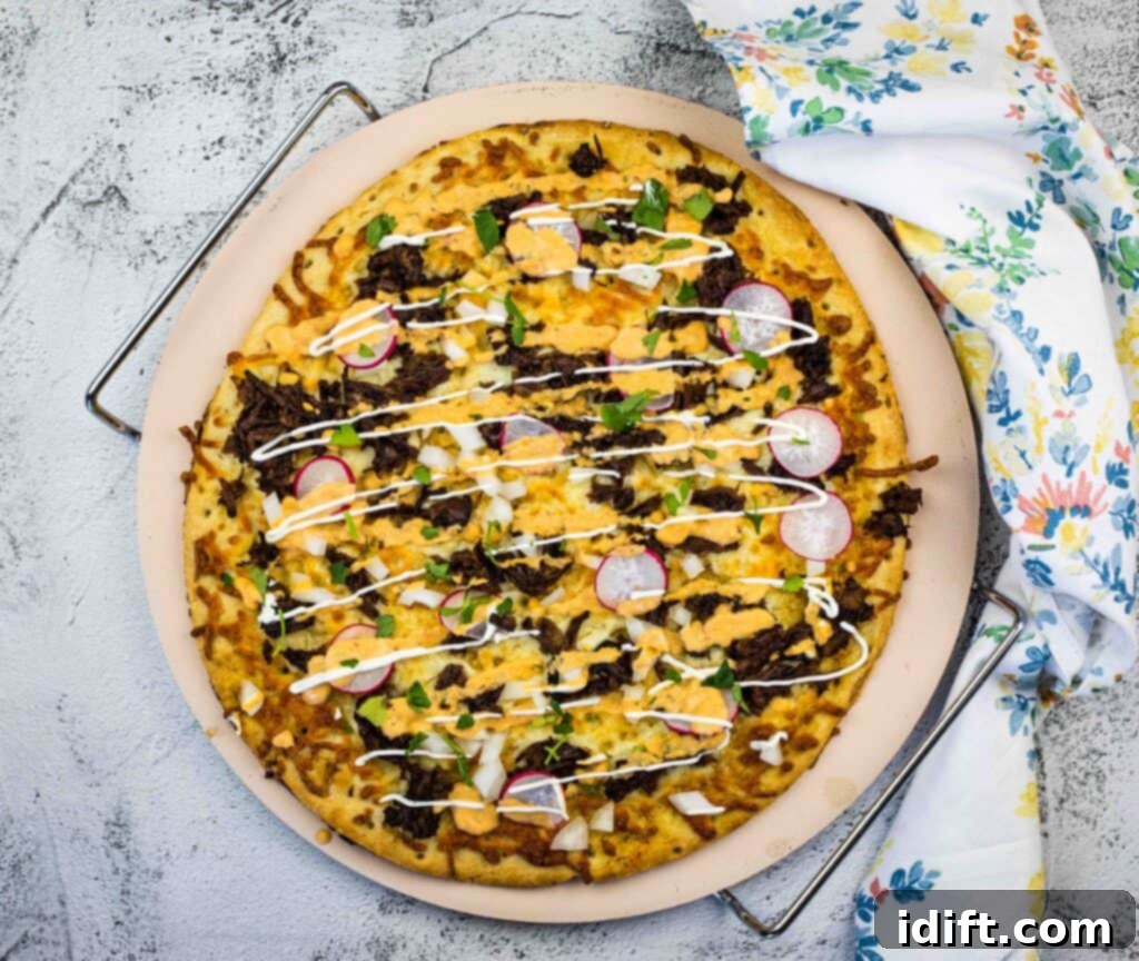 birria pizza on a pizza stone