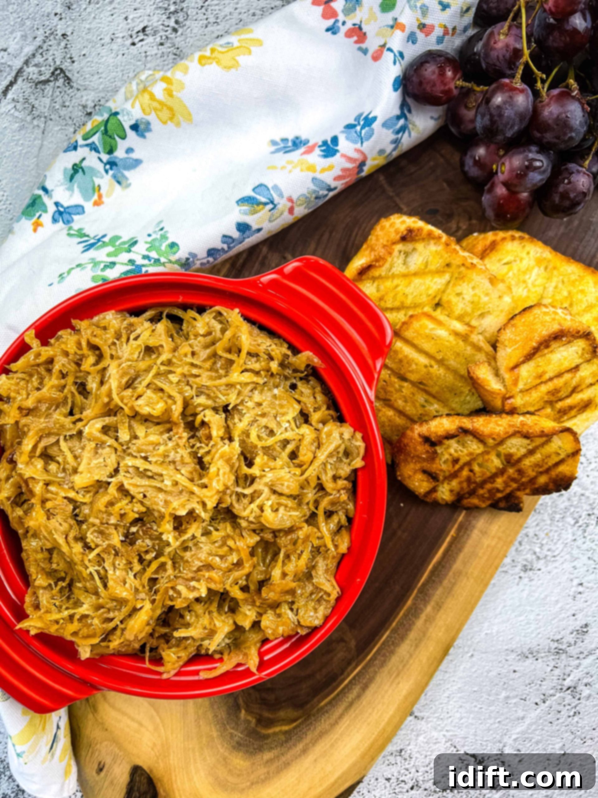 caramelized onions on a platter with toasted bread and grapes