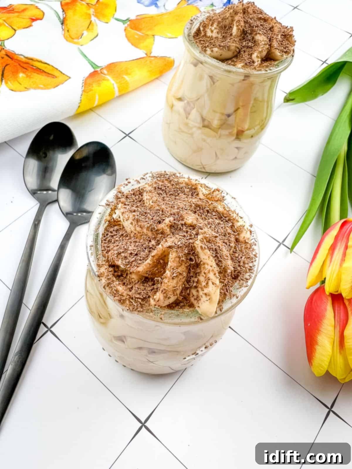 Two glass cups filled with creamy Dulce de Leche Mousse, topped with delicate chocolate shavings, ready to be served as a decadent dessert.