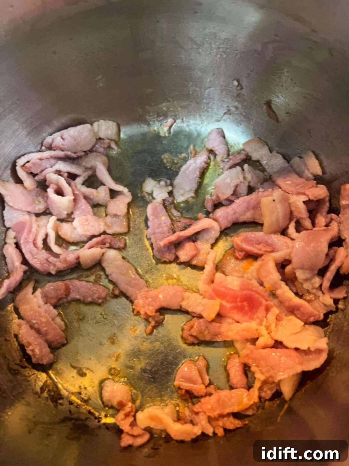 Crispy bacon frying in a large soup pot, rendering its fat to create a flavorful base for the chowder.