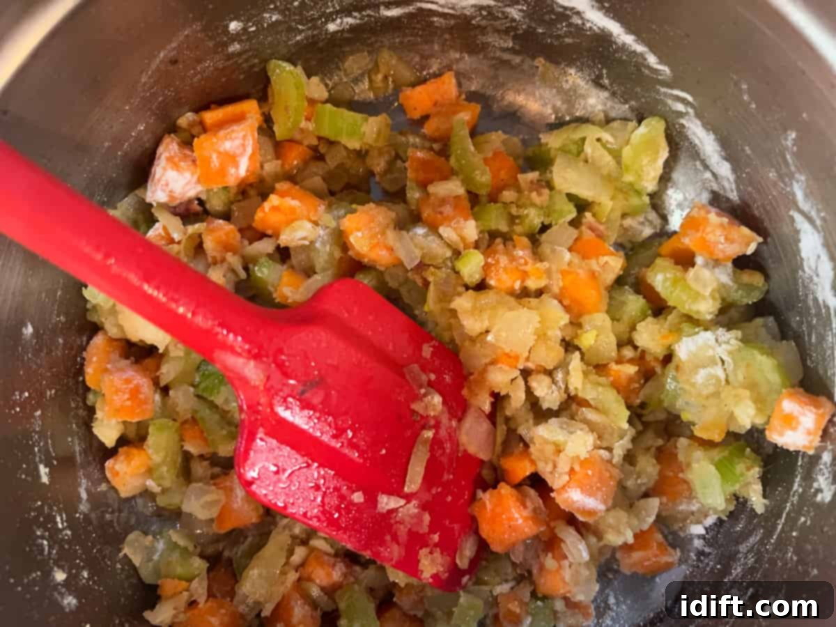 Flour being added to the sautéed vegetables after deglazing with wine, creating a roux to thicken the chowder.
