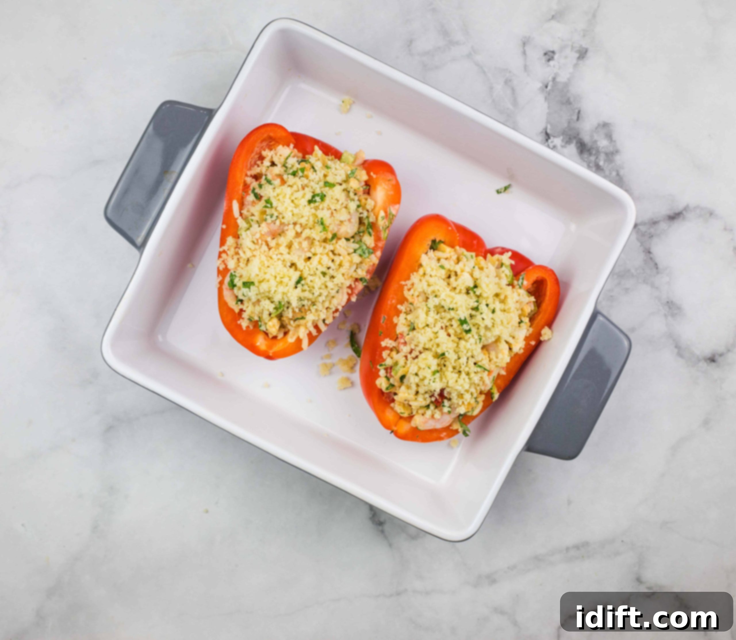 Seafood stuffed bell peppers in a baking dish, ready for the oven