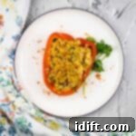 Seafood-stuffed red peppers on a white plate, garnished