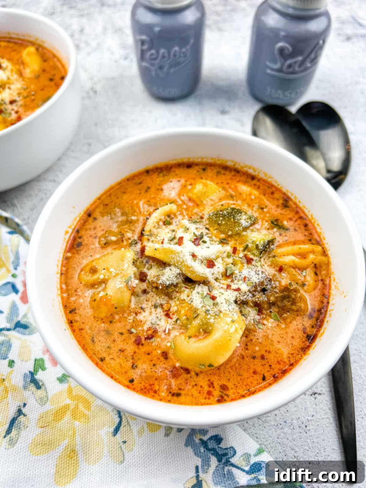 Creamy Instant Pot Sausage and Tomato Tortellini Soup 2 Creamy Instant Pot Tortellini Soup with Sausage in a bowl with spoons, ready to be served and enjoyed