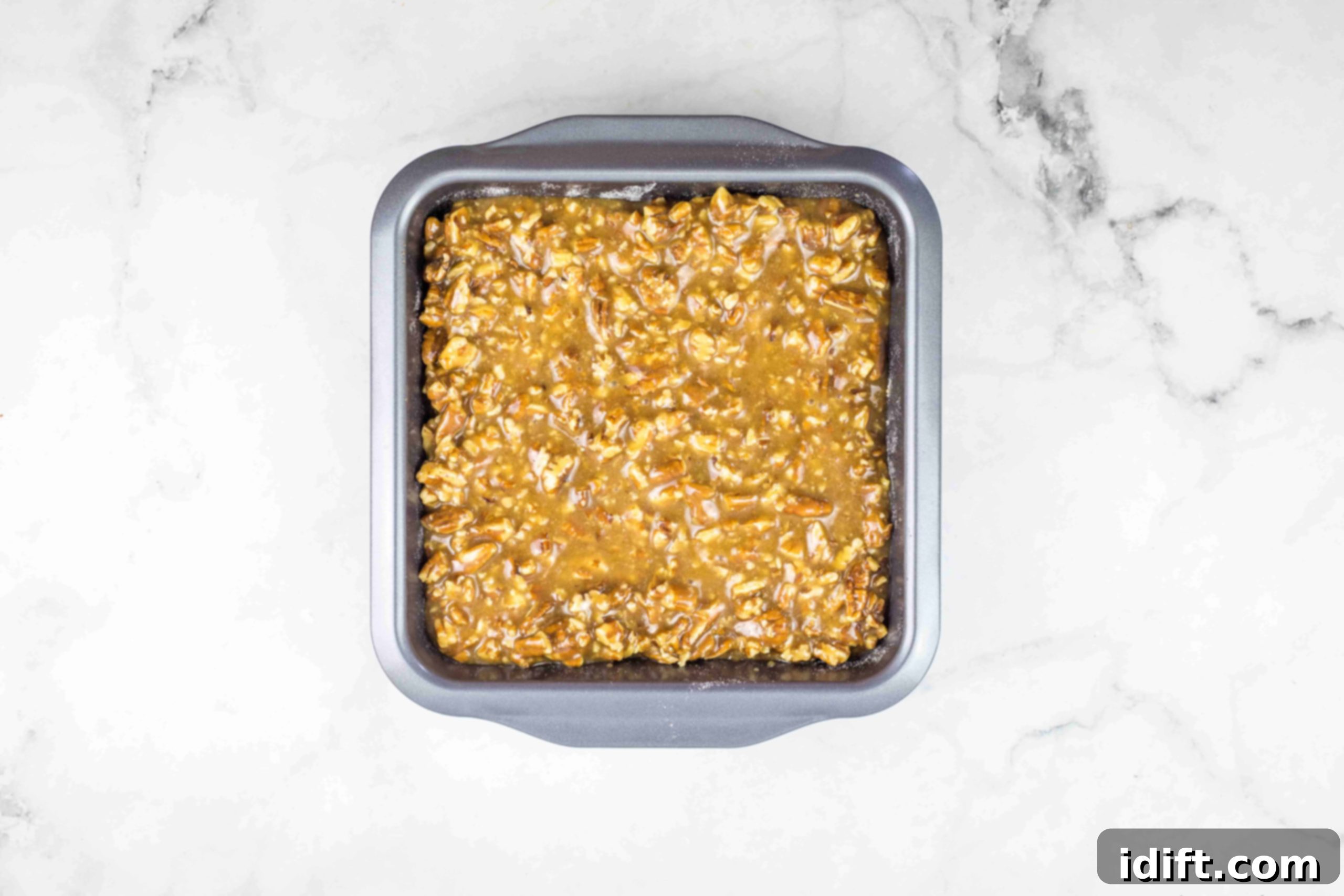 maple pecan pie bars in a baking dish ready for the oven.