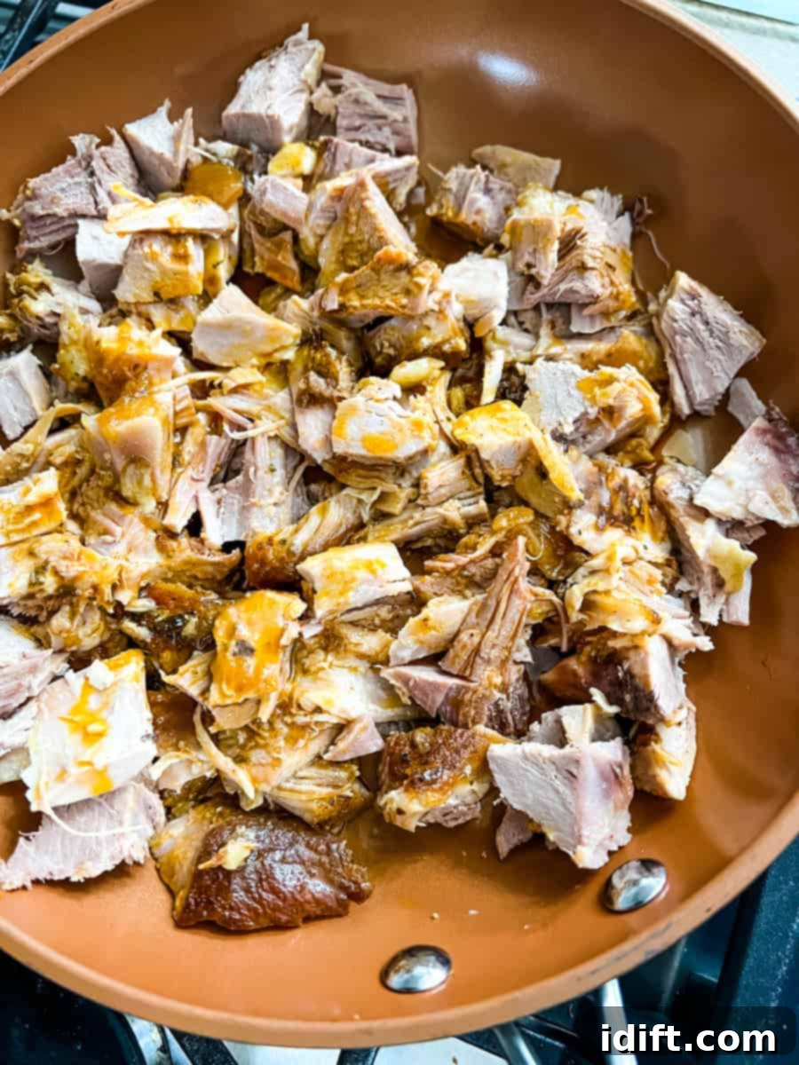 Ultimate Dutch Oven Pork Carnitas 11 Pulled dutch oven carnitas meat in a skillet for crisping.