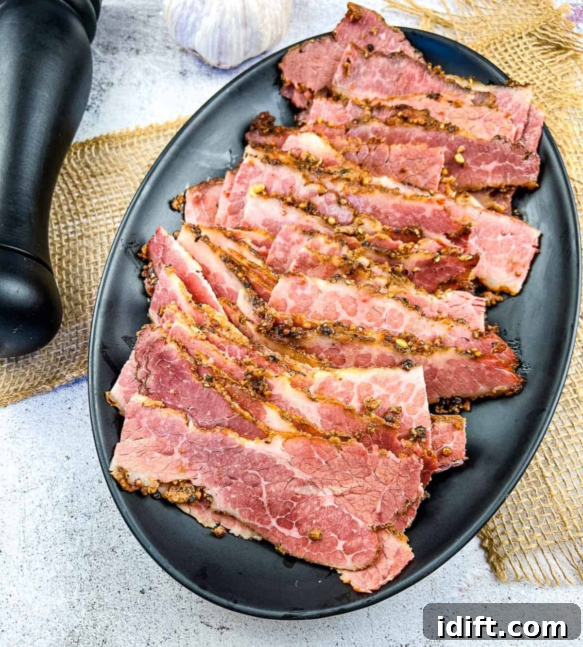 sliced pastrami on a plate, showcasing its beautiful pink hue and rich texture