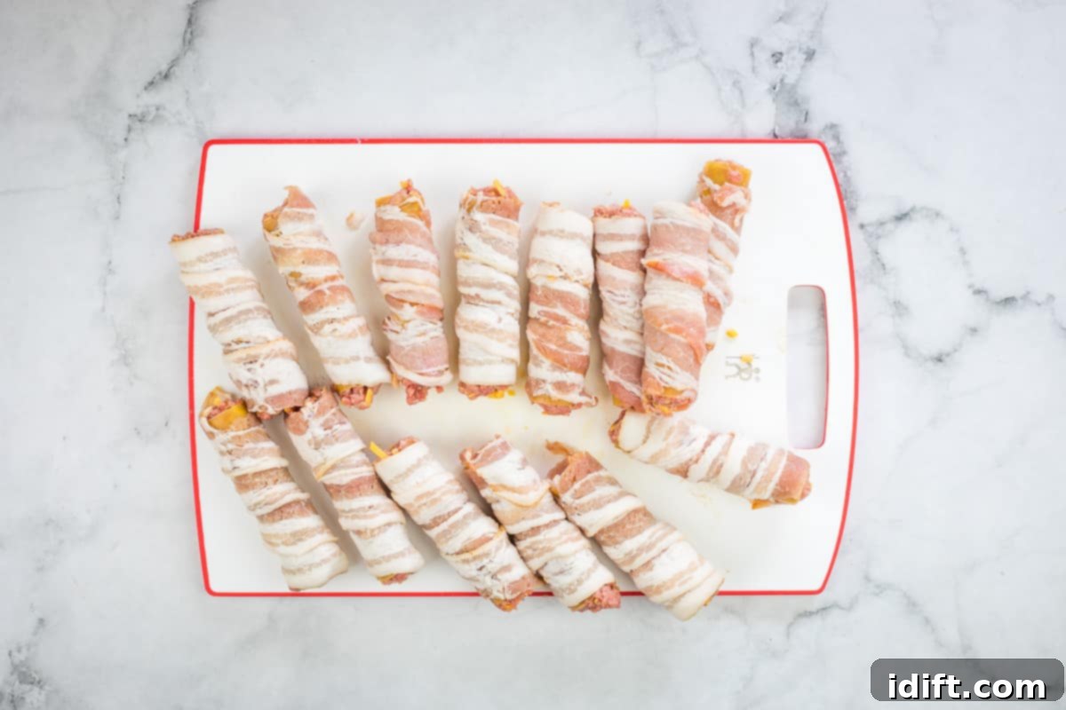 Bacon-wrapped shotgun shells arranged on a tray.