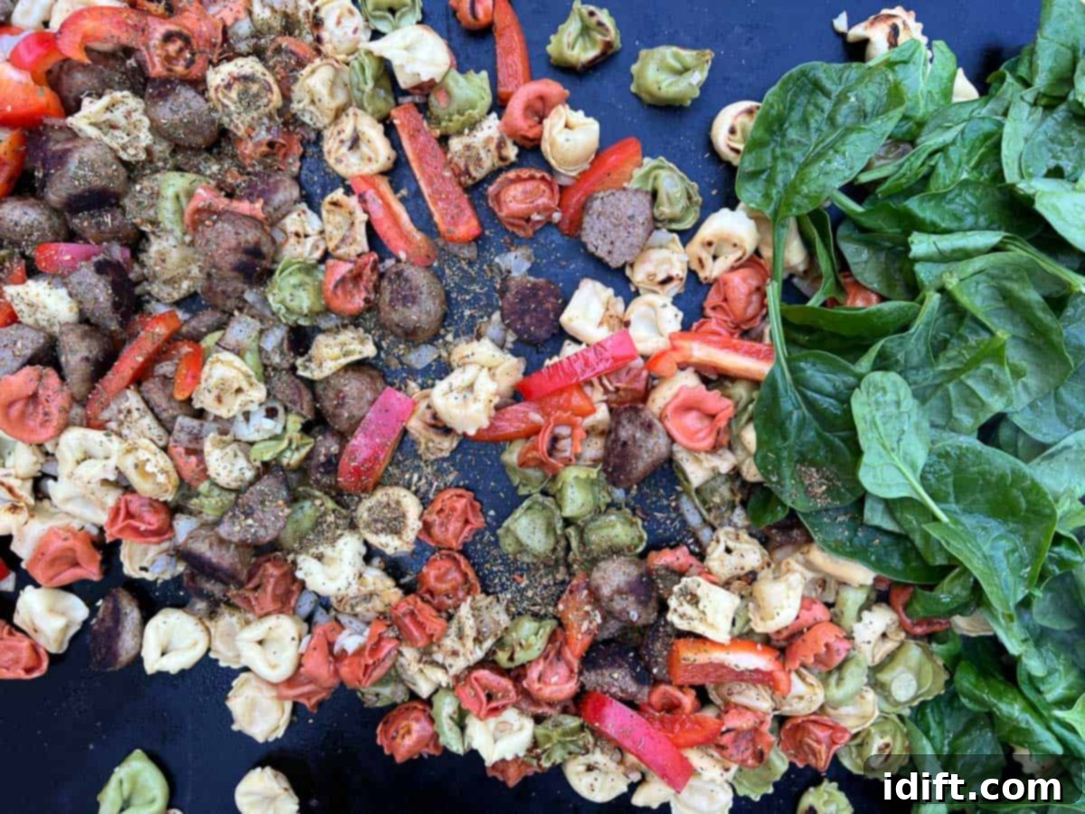 spinach, tomatoes, and seasoning added to tortellini and meatballs.