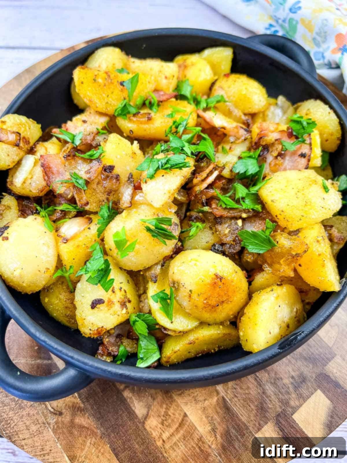 blackstone fried potatoes in a black dish on a cutting board