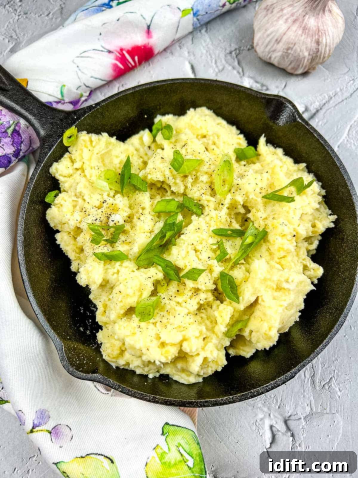 Fireside Mash 2 Smoked mashed potatoes served in a rustic cast iron pan, ready to be enjoyed.