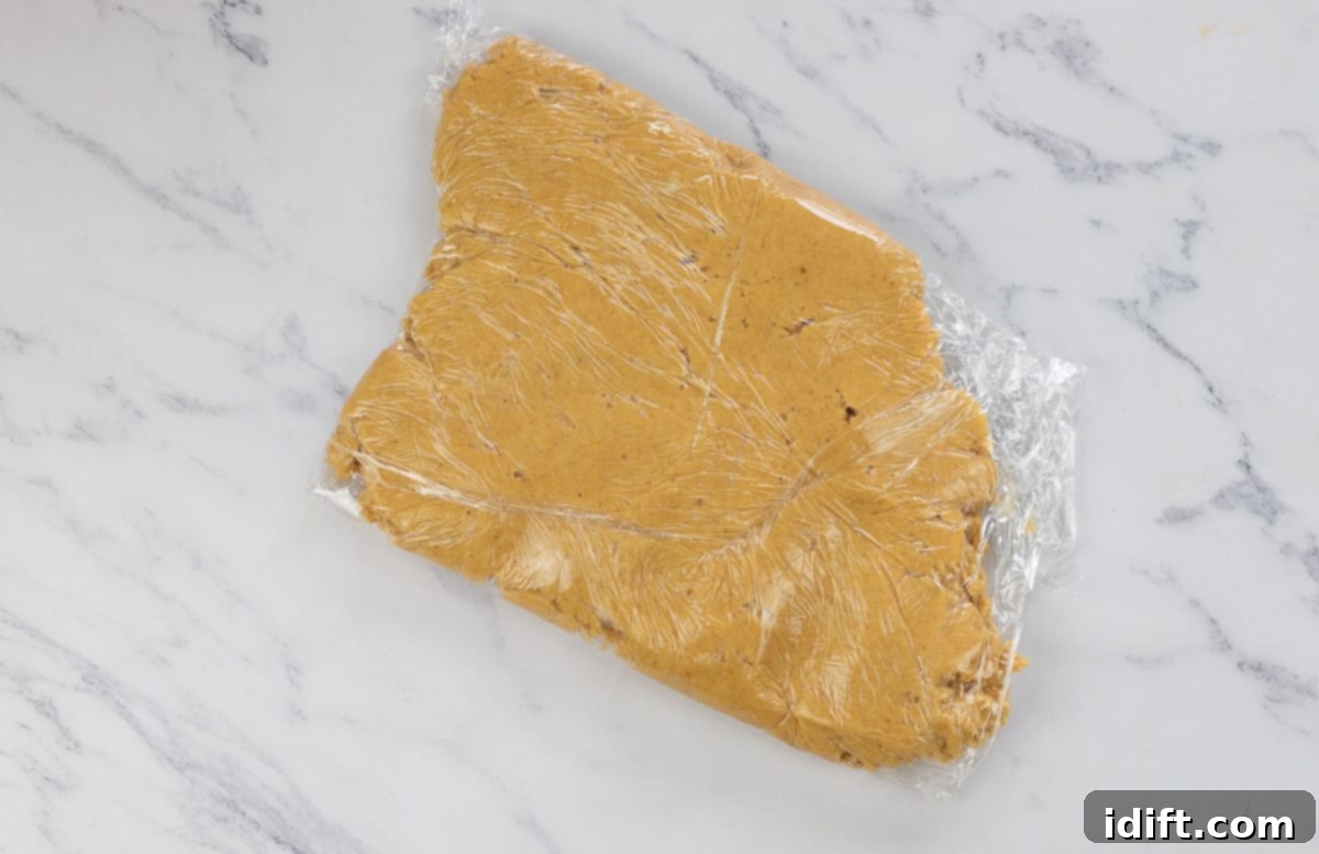 Cookie dough wrapped in plastic wrap and chilling in the refrigerator.