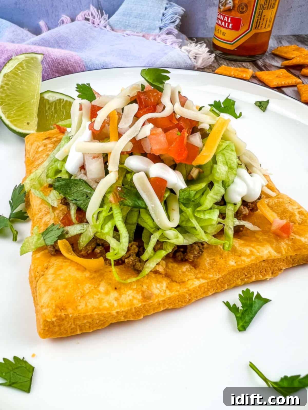 Cheez-It Tostada on a white plate, showcasing a perfectly golden-brown cracker base topped with fresh ingredients.