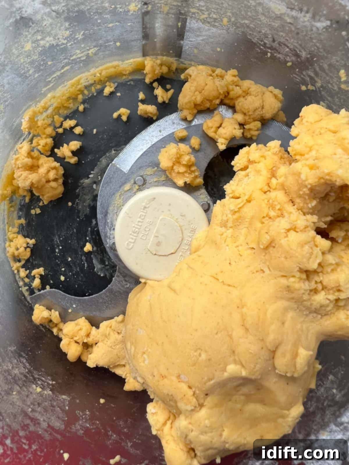 Cheez-It tostada dough forming into a ball in the food processor after adding ice water.