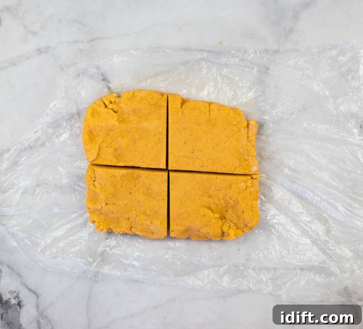 Chilled Cheez-It dough divided into quarters for easier rolling.